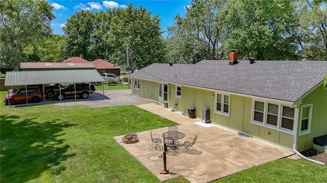 Rear view of property featuring a shingled roof, board and batten siding, a chimney, and a yard | Image 51