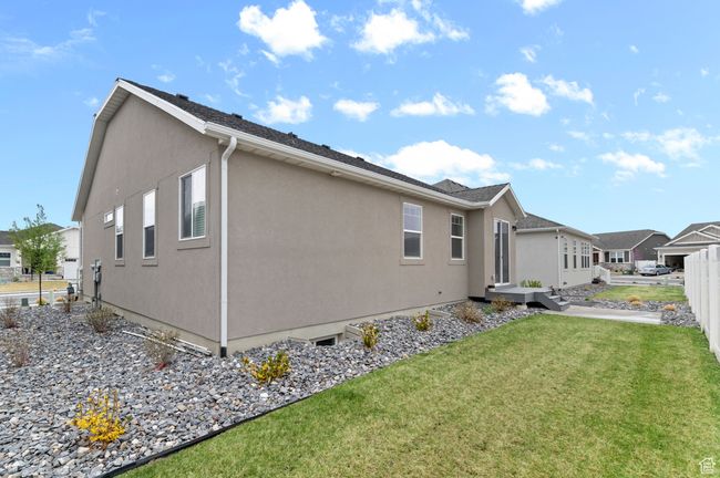 View of side of property featuring a lawn, fence, and stucco siding | Image 4