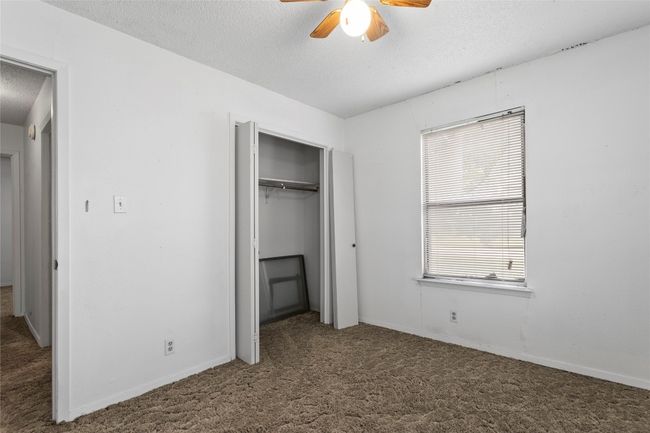 Unfurnished bedroom with a textured ceiling, carpet floors, a closet, and ceiling fan | Image 22