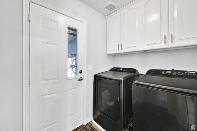 Laundry area featuring visible vents, washing machine and clothes dryer, and cabinet space | Image 25