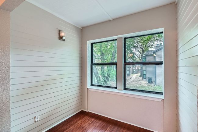 Unfurnished room with dark wood-style flooring and wooden walls | Image 8