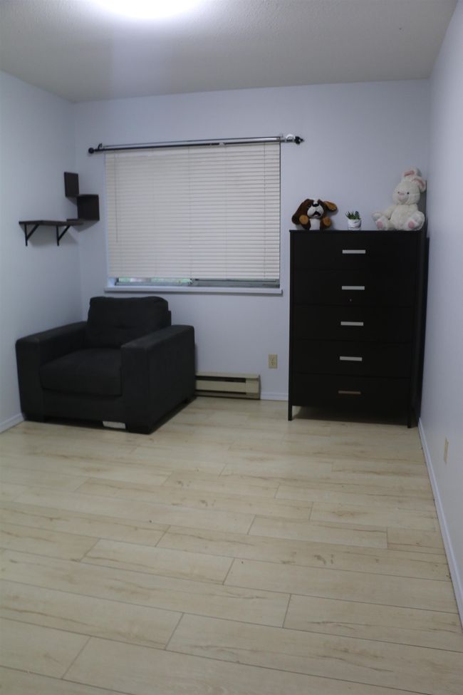 Living area with light wood-type flooring and a baseboard radiator | Image 15