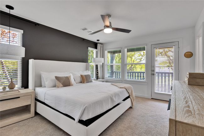 Carpeted bedroom with access to outside, multiple windows, visible vents, and ceiling fan | Image 16