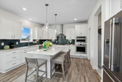 (Photo of decorated model, finishes will vary) This stylish kitchen showcases a large center island, Shaker-style cabinetry, and brand-new stainless-steel appliances. | Image 2