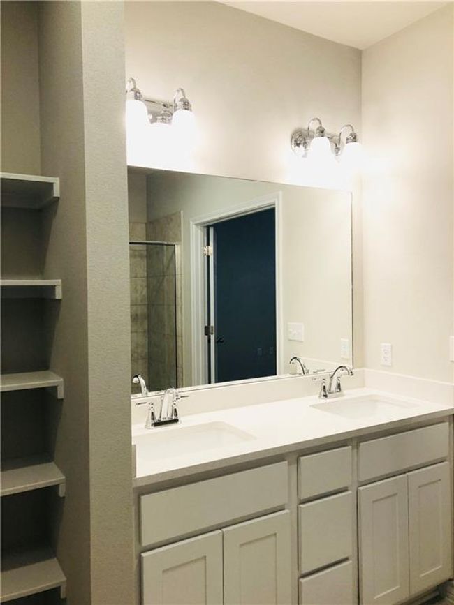 Bathroom featuring double vanity and a shower stall | Image 16