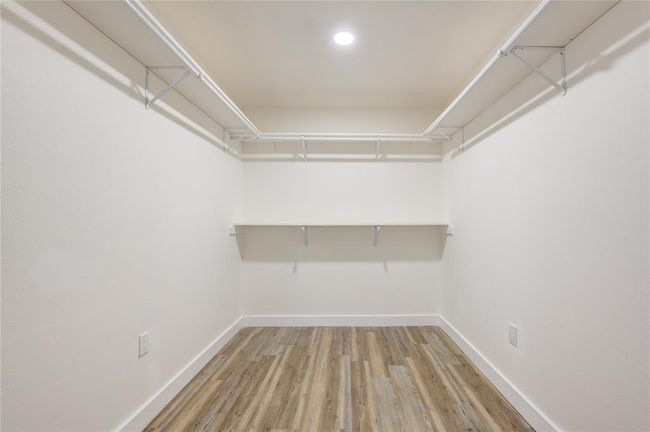 The primary bedroom features a spacious walk-in closet, providing an abundance of storage space for your wardrobe and accessories. Designed with built-in shelving and hanging racks, it offers easy organization and easy access to your clothes and shoes. | Image 21