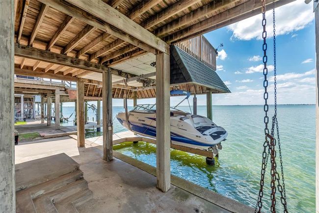 Just steps from the house, this covered boat lift and slip make it easy to hop on the water anytime. | Image 29