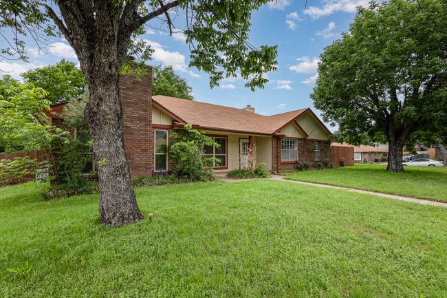 Single story home featuring a chimney, a front lawn, and brick siding | Image 5