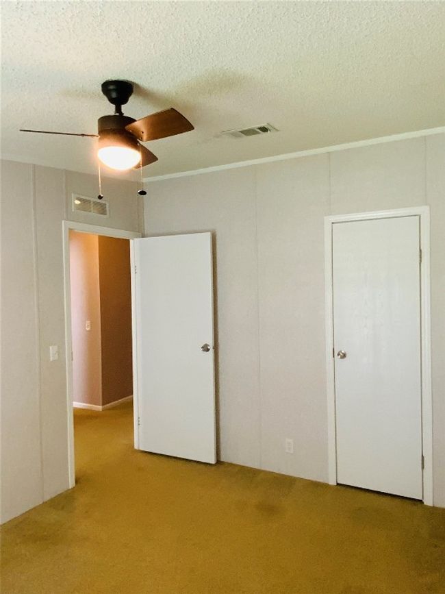 Unfurnished bedroom with a textured ceiling, visible vents, and carpet flooring | Image 26