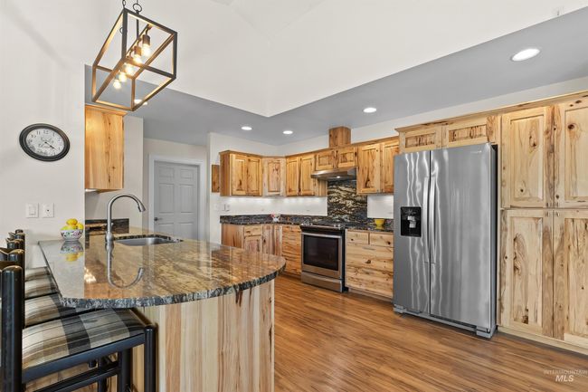 Kitchen with appliances with stainless steel finishes, under cabinet range hood, a peninsula, recessed lighting, and wood finished floors | Image 6