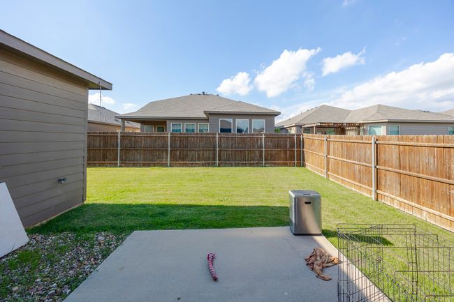 Fenced backyard with a patio | Image 26