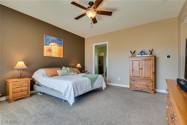 Bedroom featuring baseboards, light colored carpet, and ceiling fan | Image 53