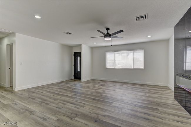 Unfurnished living room featuring light wood-type flooring, a ceiling fan, recessed lighting, and baseboards | Image 5