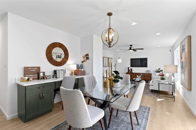 Dining room with light wood-type flooring and ceiling fan with notable chandelier | Image 31