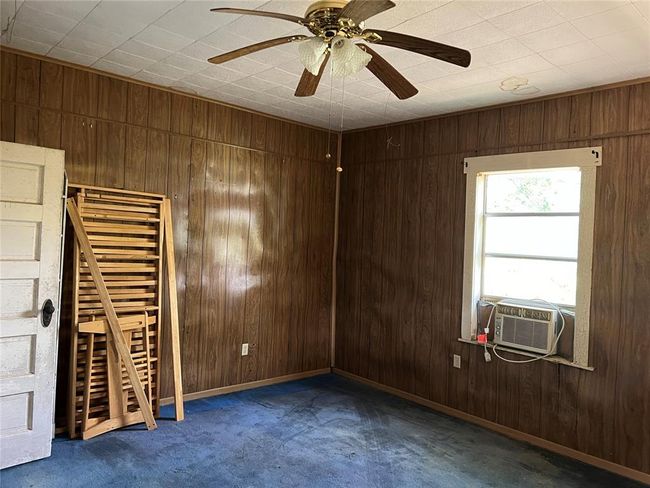 Carpeted spare room with wooden walls and ceiling fan | Image 29