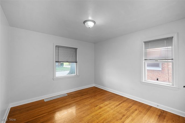 bedroom featuring baseboards, light wood-type flooring, and visible vents | Image 12