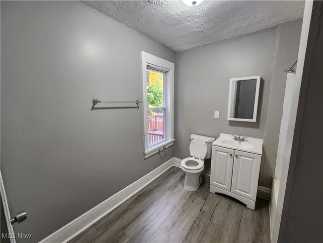 Bathroom featuring vanity, toilet, wood-type flooring, and a textured ceiling | Image 13