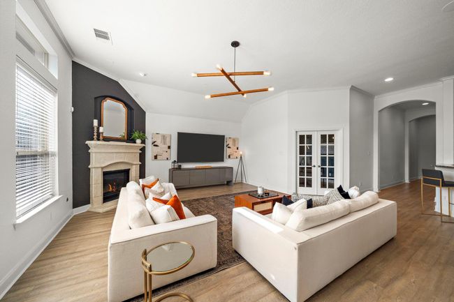 Effortlessly combining comfort and style, the living room features expansive windows and designer lighting fixtures. A cozy fireplace enhances warmth, while the open layout offers seamless access to a home office and patio, making it ideal for gatherings or serene retreats. | Image 13