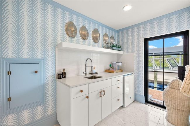 Bar with a sink, crown molding, wet bar, refrigerator, and wallpapered walls | Image 35