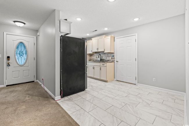 Kitchen featuring freestanding refrigerator, a textured ceiling, tasteful backsplash, and recessed lighting | Image 11
