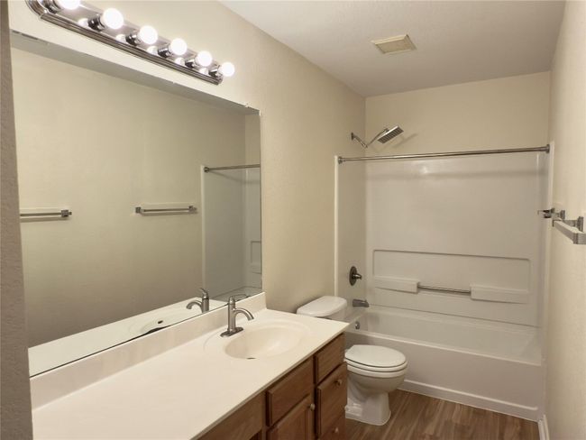 Bathroom with wood finished floors, vanity, and shower / bathtub combination | Image 33