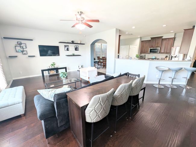 Living area featuring arched walkways, ceiling fan, dark wood-style flooring, and recessed lighting | Image 21