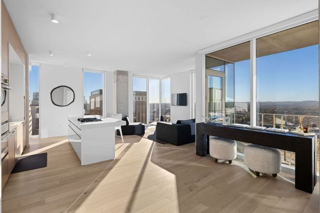 Living area with expansive windows and light wood-style flooring | Image 9