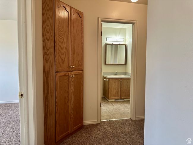 Hall with built-in cupboards for storage and a peek into the bathroom | Image 16