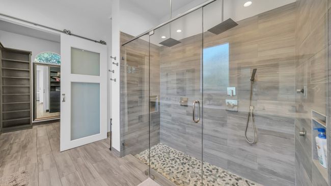 Bathroom featuring a shower stall, a spacious closet, wood finished floors, and recessed lighting | Image 22
