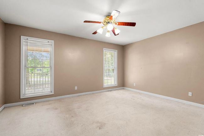 Empty room featuring plenty of natural light, ceiling fan, and carpet | Image 24