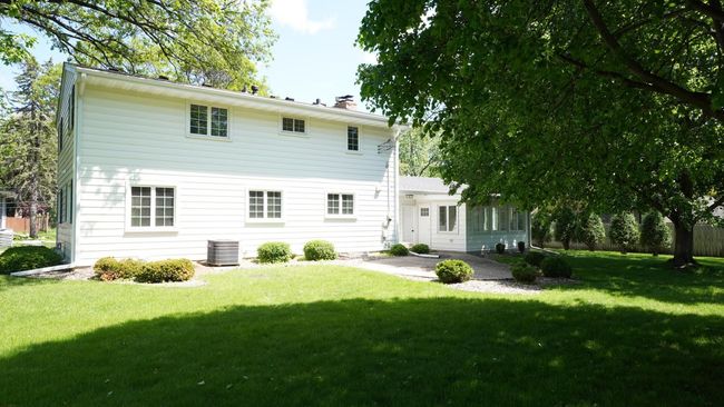 The oversized, flat backyard of 5317 Maddox Lane has several mature trees, tidy landscape beds and direct access to both the garage and sunny four season porch. | Image 44