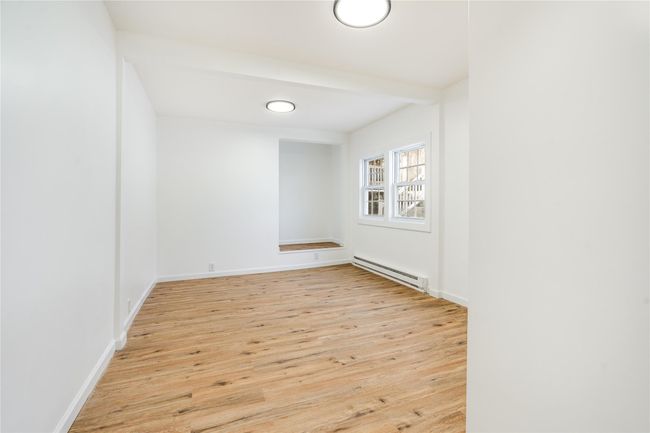 Spare room featuring a baseboard heating unit, wood finished floors, and baseboards | Image 13