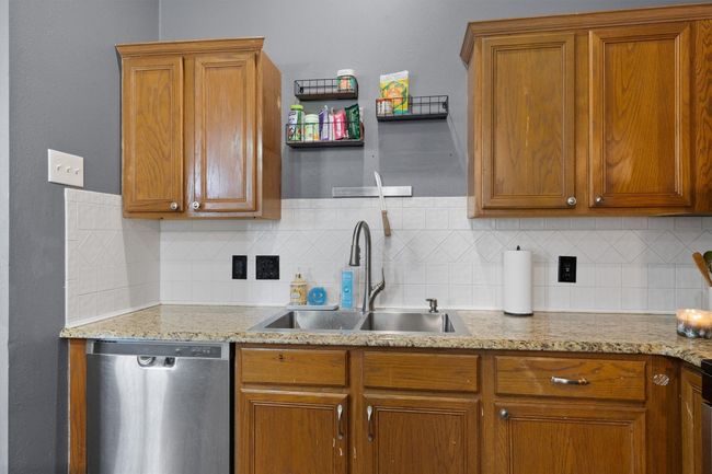 Kitchen featuring dishwasher, a sink, tasteful backsplash, and brown cabinets | Image 9