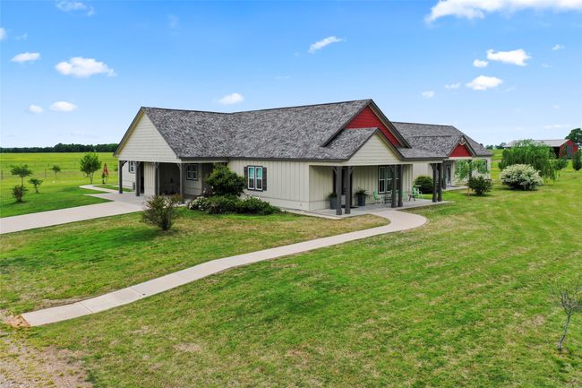 View of front of house featuring roof with shingles, board and batten siding, and a front yard | Image 5