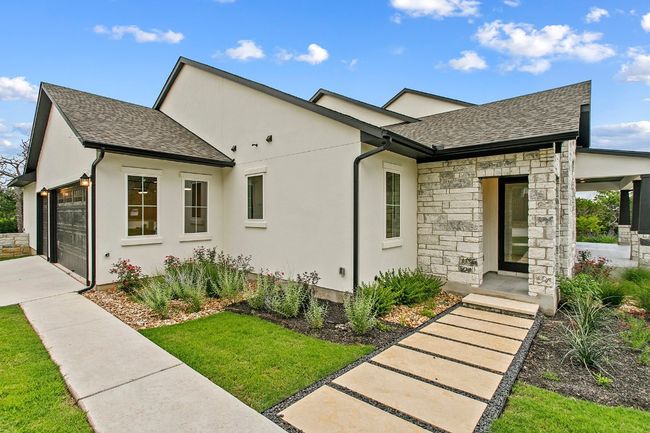View of front of property with a shingled roof, stone siding, a garage, concrete driveway, and stucco siding | Image 35