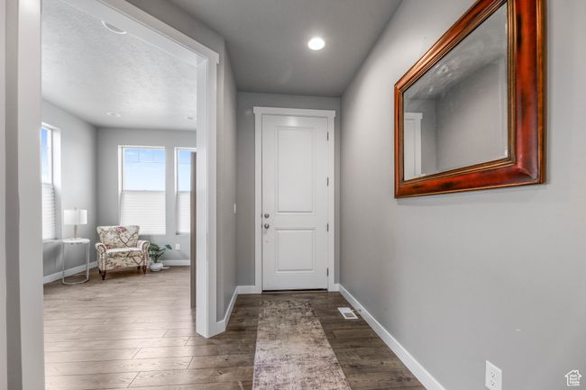 Doorway to outside with dark wood-type flooring, visible vents, baseboards, and recessed lighting | Image 8