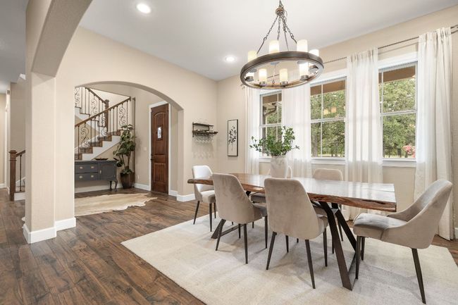 Tall windows bring natural light to the dining space and recessed lighting throughout the home. | Image 6