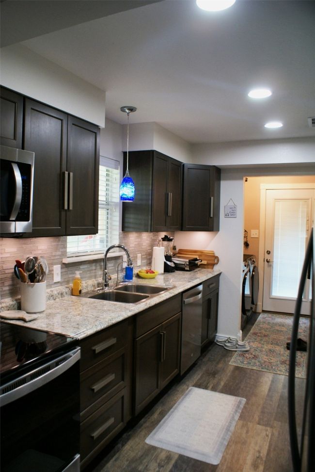 Kitchen with stainless steel appliances, dark wood-style flooring, tasteful backsplash, pendant lighting, and recessed lighting | Image 15