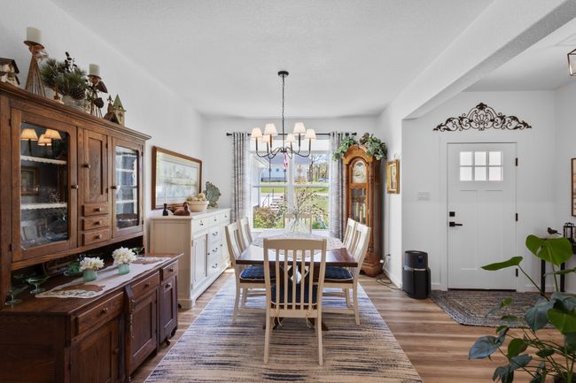 Dining room with wood finished floors and a notable chandelier | Image 6