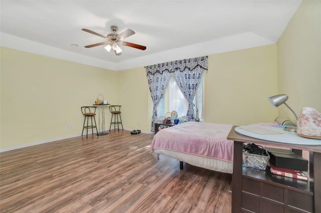 Bedroom featuring wood finished floors, baseboards, and a ceiling fan | Image 18