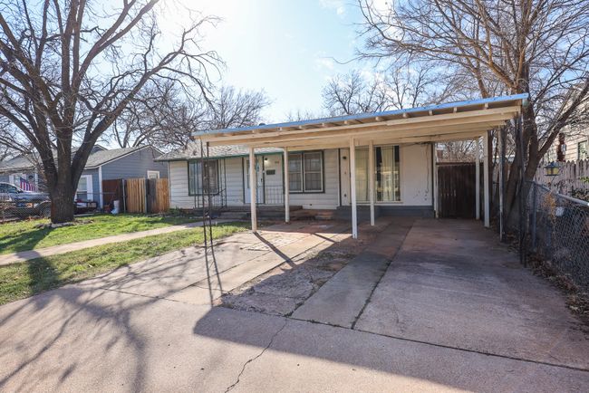 View of front facade with fence, a porch, and a carport | Image 32