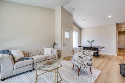 Living room with light hardwood / wood-style floors and high vaulted ceiling | Image 3