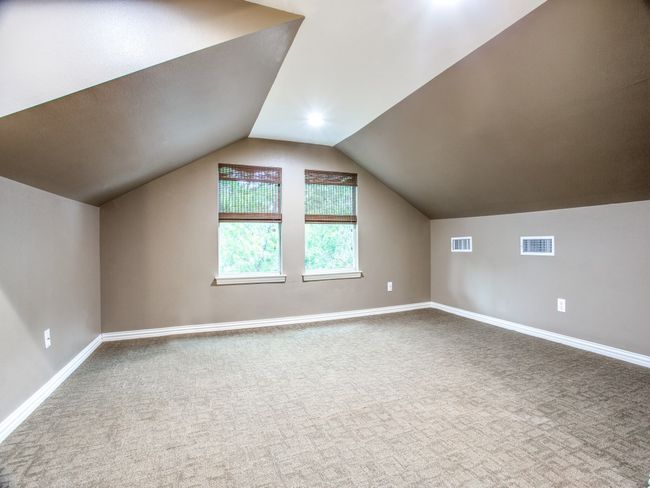 Bonus room featuring visible vents, carpet floors, baseboards, and vaulted ceiling | Image 16