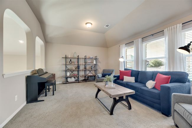 Carpeted living room with baseboards and lofted ceiling | Image 25