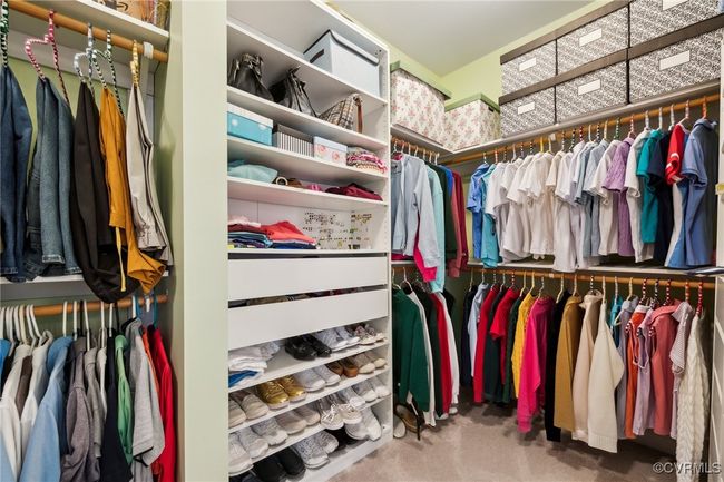 Primary walk-in closet (right side). Adjustable shelving, upper & lower clothing rods, and shoe racks. | Image 22