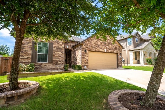 View of front of home featuring an attached garage, concrete driveway, and brick siding | Image 31