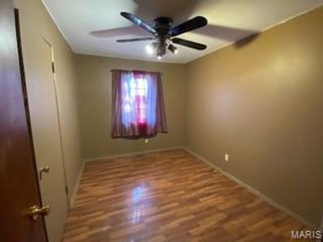Unfurnished room featuring a ceiling fan, wood finished floors, and baseboards | Image 8