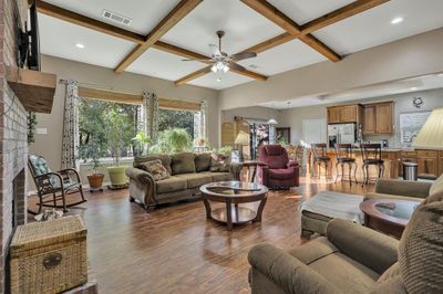 Open family room boasts gorgeous ceiling beams, large picture windows and rich flooring. | Image 3