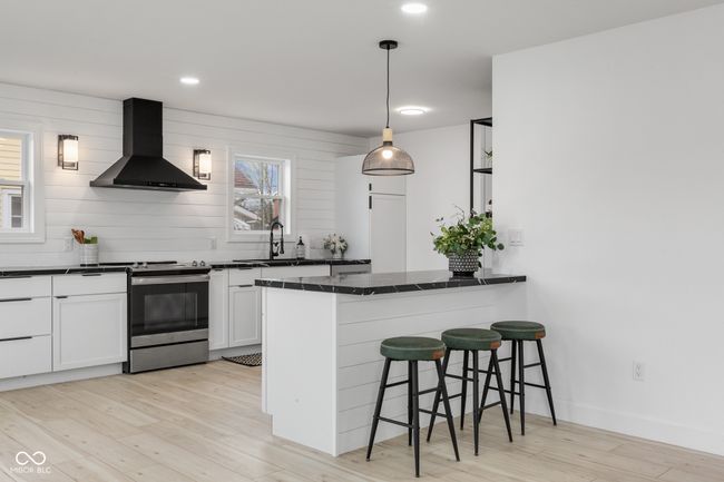 kitchen with extractor fan, a sink, stainless steel electric stove, and dark countertops | Image 23