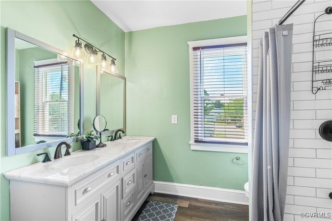 Full bath with baseboards, a shower with shower curtain, a sink, and double vanity | Image 30